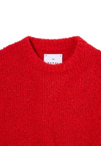 Červený pletený svetr s texturovaným, huňatým povrchem. Disponuje ribkovaným kulatým výstřihem a štítkem uvnitř límce.