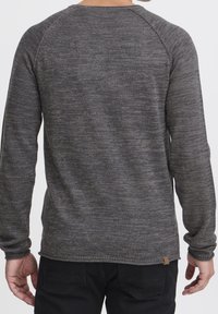 Grauer langärmliger Strickpullover mit strukturiertem Muster. Verfügt über Raglanärmel und ein Markenetikett an der unteren linken Naht.