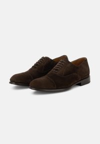 Un paio di scarpe eleganti in suede marrone scuro, con lacci, punte chiuse e tacchi bassi, su uno sfondo bianco.