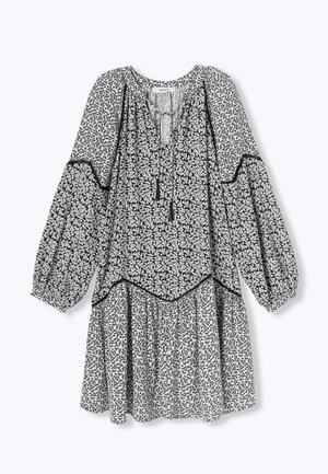 Robe florale noir et blanc avec des manches bouffantes, un décolleté en trou de serrure et une jupe à volants, présentant une bordure noire le long des coutures et des bords.