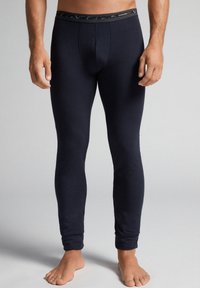 Marine termisk leggings med en tætsiddende pasform, lavet af blødt stof. Har en mørk mønstret talje og ingen synlige sømme.