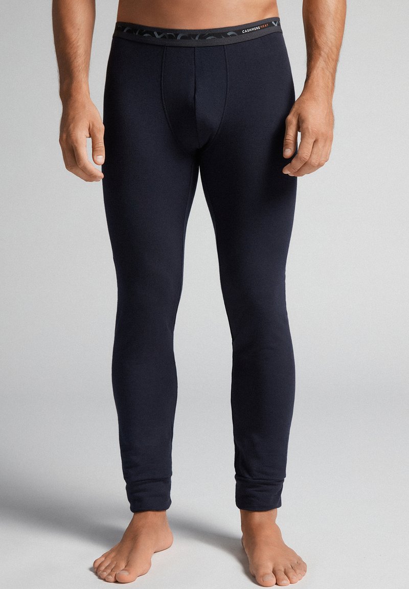 Marine termisk leggings med en tætsiddende pasform, lavet af blødt stof. Har en mørk mønstret talje og ingen synlige sømme.