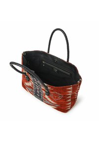 Grote tote tas met een gevlochten rood en crèmekleurig patroon, zwart gevlochten handvatten en een ritsvakje aan de binnenkant. Stoffen buitenkant met een gestructureerde vorm.