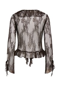 Blouse longue manches longues en dentelle noire transparente avec motifs floraux, ourlet à volants et détails à nouer aux poignets et dans le dos.