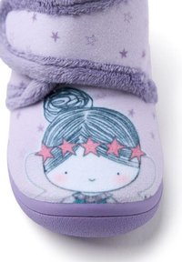 Zapatilla de felpa morada con un dibujo animado que tiene el pelo azul y una diadema de estrellas. Parte superior y suela texturizadas para mayor comodidad, decoradas con pequeñas estrellas.