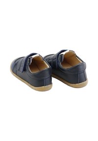 Zapatos de cuero azul marino con correas de velcro, punta redondeada y suelas de goma beige. Presentan detalles en costura y una textura suave.