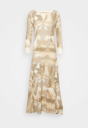 Lange beige en crèmekleurige jurk met patroon, lange mouwen en aangesloten manchetten op een effen witte achtergrond.