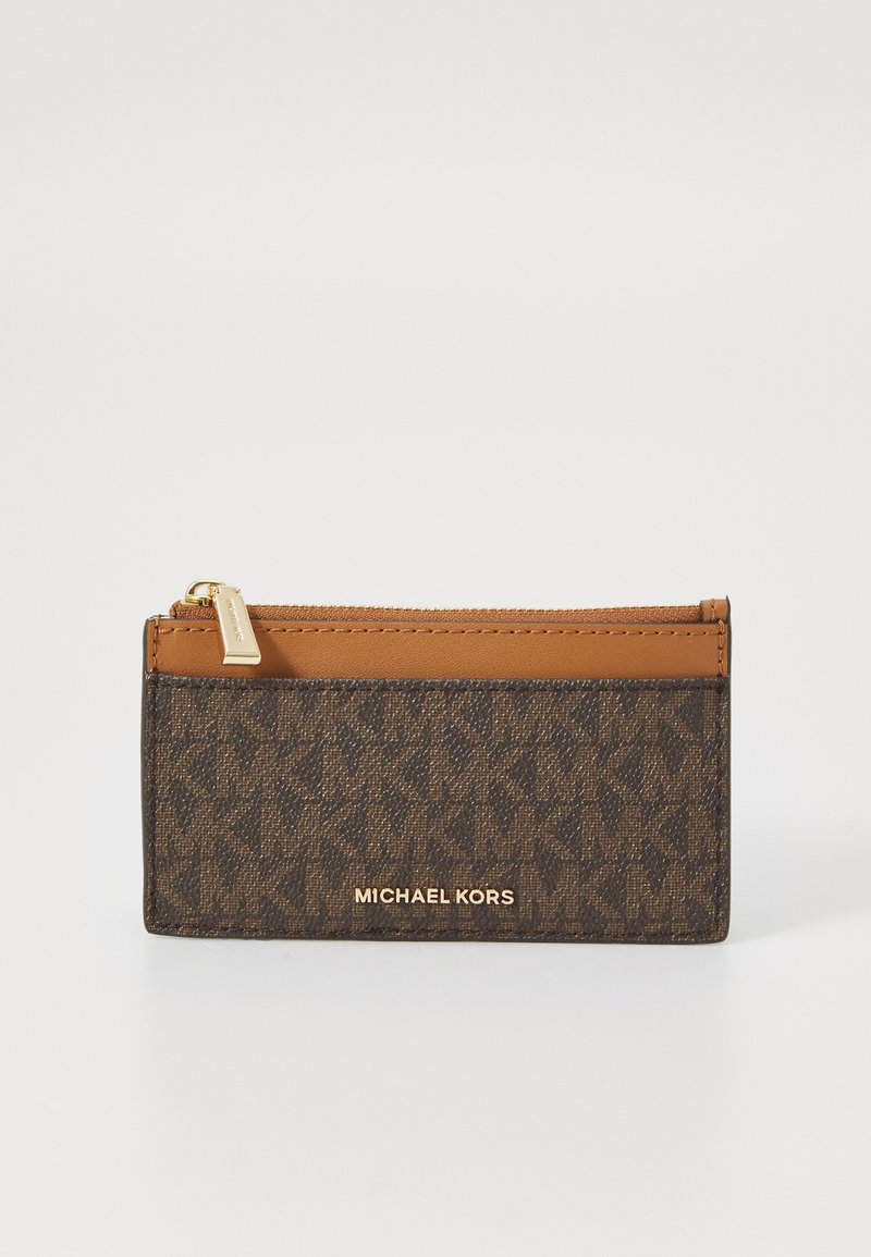 Portefeuille en toile marron avec des accents en cuir beige, fermeture zippée, logo embossé et motif géométrique. Forme compacte et rectangulaire. Quincaillerie dorée.