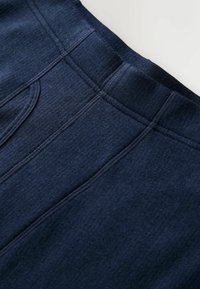 Tengerészkék szövet sima textúrával, varrott varratokkal és kényelmes derékrésszel, döntött szögben, hogy részletek és forma látható legyen.