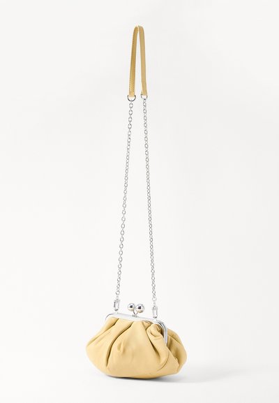 Gul læderhåndtaske med en samlet design, sølv hardware og en kort kædetras. Har en låseanordning med to ronde knopper.