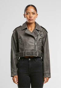 Beskåret grå kunstskinnjakke med belted midje, sølvglidelåser, skulderepauleter og kontrasterende hvite sømdetaljer.