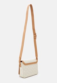 Borsa crema con tracolla in pelle marrone, forma rettangolare, superficie testurizzata con motivo geometrico e chiusura a patta pieghevole.