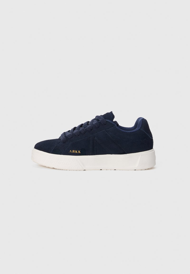 Adidași din suede albastru marin cu talpă din cauciuc alb. Prezintă șireturi rotunde, un design cu profil redus și un mic logo aurit pe lateral.