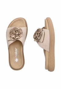 Sandali a scivolo beige in suede con suola in gomma testurizzata, caratterizzati da un accento floreale sulla fascia e dal marchio "Antistress" sulla soletta.
