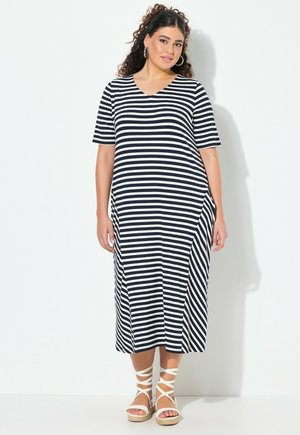 Abito a righe, blu e bianco, lungo fino al ginocchio, con maniche corte, scollatura a V e tasche laterali, abbinato a sandali bianchi con cinturini.