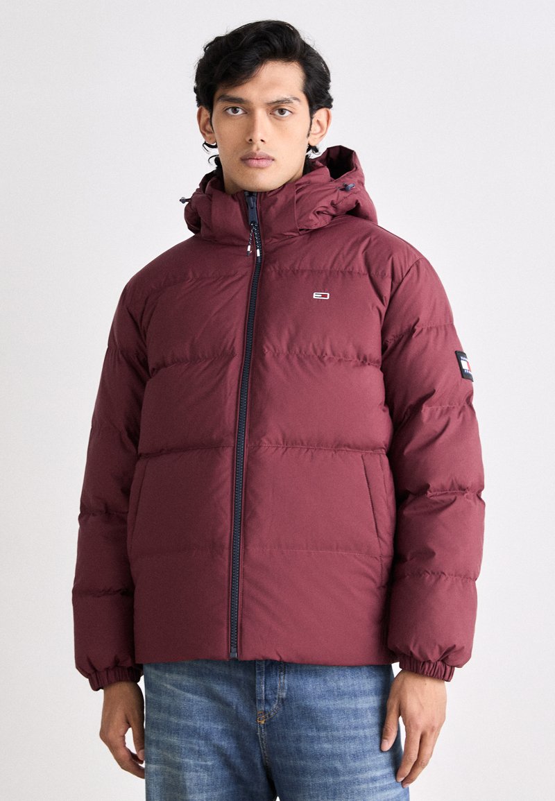 Maroon puffer jacket with a zippered front, elastic cuffs, and a hood. The fabric has a smooth finish with a lightweight, insulated design.