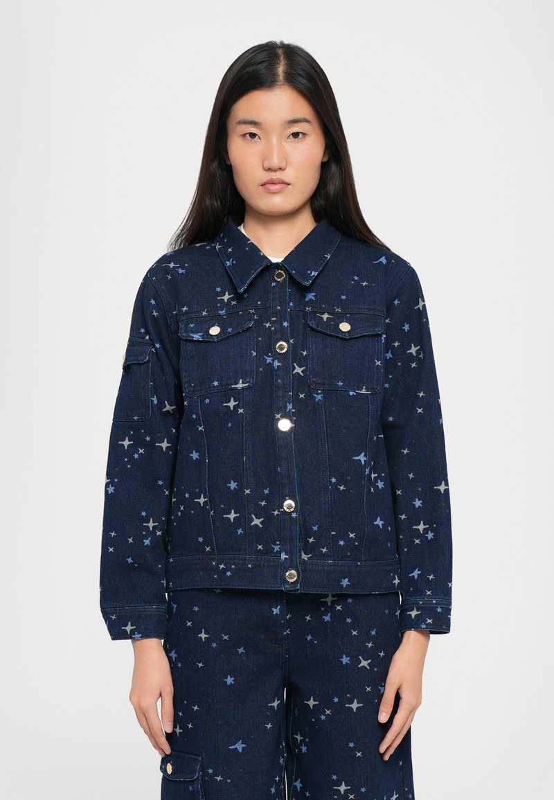 Denim jaka tumši zilā krāsā ar zvaigžņu rakstiem gaiši zilā un pelēkā tonī. Divas krūšu kabatas, pogu aizdare un apkakles kakla izgriezums.