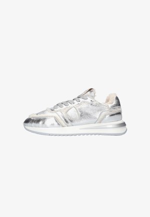 Silver metallic sneaker with a textured finish, soft beige accents, and a padded collar. Features white chunky sole and grey laces.