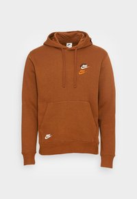 Sudadera Nike marrón con bolsillo frontal, capucha con cordón y tres acentos del logo en negro y naranja. Fabricada en suave material de algodón.