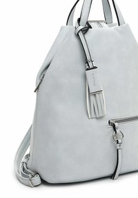 Sac à dos en cuir gris clair avec poche zippée à l'avant, bretelles doubles et pampille en cuir décorative avec ferrures métalliques.