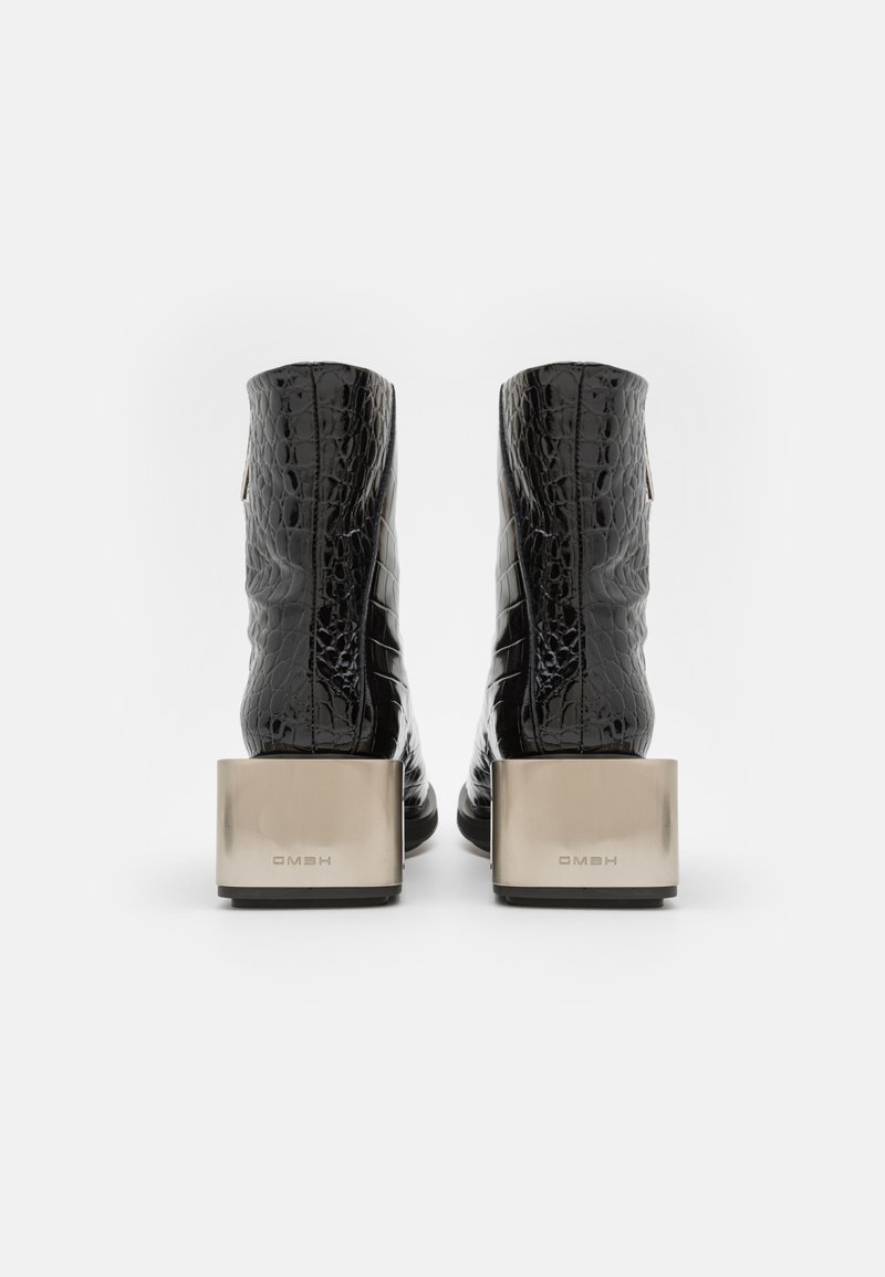 Zwarte enkellaarsjes met krokodillenprint, uitgerust met een stevige metalen blokhak, een gladde afwerking en een ritsdetail aan de binnenkant.