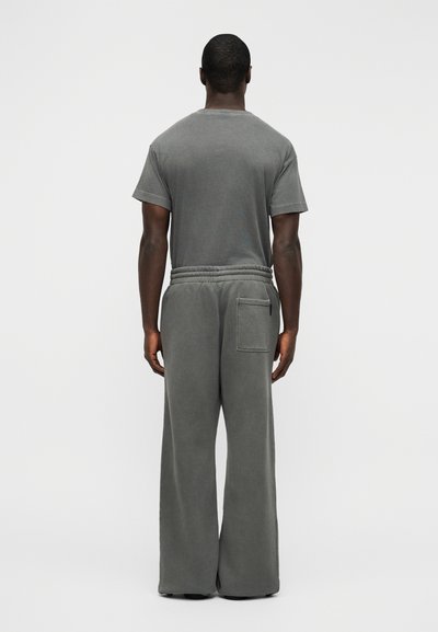 Γκρι βαμβακερό T-shirt και φαρδιά φόρμα με ελαστική μέση και πίσω τσέπη, με απαλή υφή και άνετη εφαρμογή.