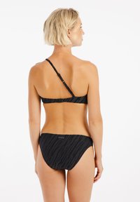 Čierny bikiny s textúrovaným zebrovým vzorom, s jedným ramienkom a nastaviteľným zapínaním. Hladká látka, minimalistický dizajn.