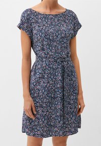 Robe à motif floral en tissu bleu marine avec manches courtes, encolure dégagée et ceinture à la taille, agrémentée de petites touches rose, blanche et bleue.