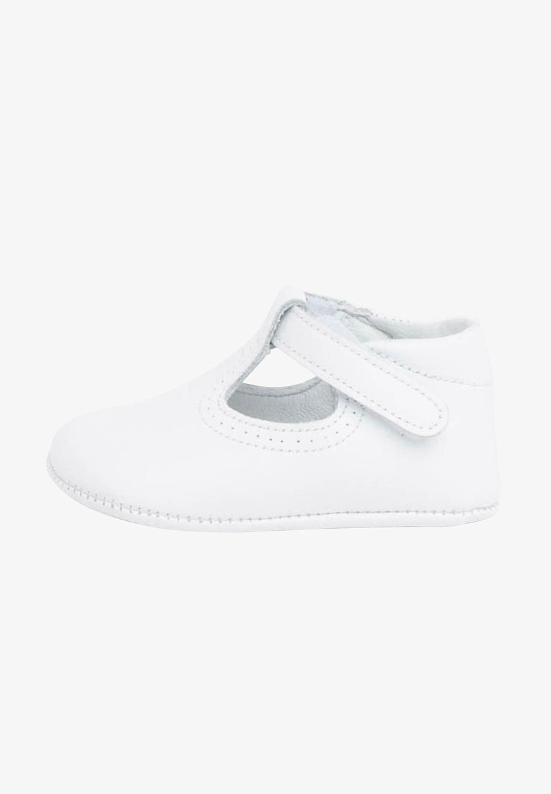 Chaussure en cuir blanc avec un bout arrondi, un design découpé et une bride à scratch. Coutures apparentes le long de la semelle. Texture lisse.