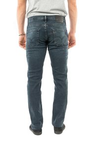 Jeans in denim blu scuro con taglio dritto, dotati di tasche posteriori e una piccola etichetta in pelle in vita. Tessuto texturizzato.