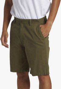 Olijfgroene katoenen shorts met een knoopsluiting, zijzakken en een relaxte pasvorm, met een nette zoom en zonder zichtbare patronen.