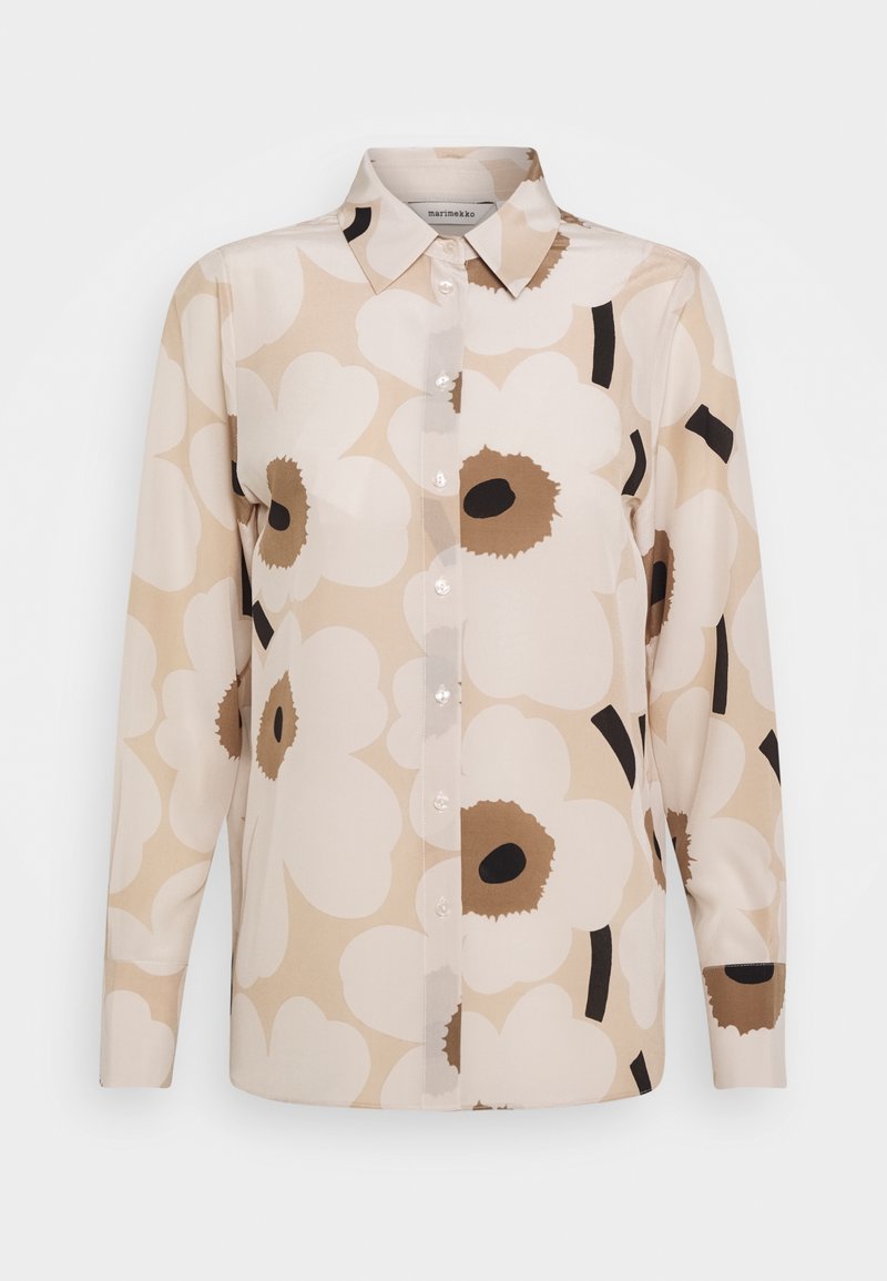 Chemise beige à manches longues boutonnée, grand imprimé floral blanc et marron, col pointu.