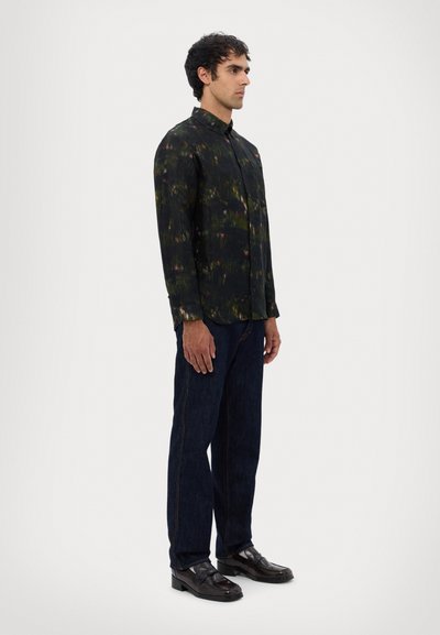 Cămașă neagră cu mâneci lungi, cu un model abstract verde și violet, cu nasturi, asortată cu blugi negri și pantofi lustruiți negri.