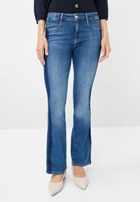 Blauwe denim flared jeans met een lichtere wassing aan de voorkant en donkerdere zijkanten. Beschikt over vijf zakken en een knoopsluiting. Soepele textuur.