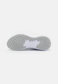 Semelle de chaussure de sport blanche avec une surface en caoutchouc texturée présentant des motifs ovales et circulaires pour une meilleure adhérence. Design minimaliste avec une forme incurvée.