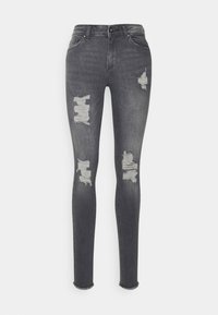 Jeans ajustados en denim gris oscuro con desgastes, que presentan detalles rasgados en las rodillas y un dobladillo sin rematar en el tobillo.