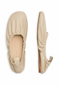 Bežiniai odiniai šokių bateliai su susiraukšlėjusia medžiaga aplink atidarymą, apvaliu priekiu ir plokščiu mediniu padu. Nėra matomų metalinių detalių ar raštų.