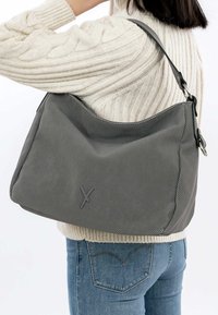Pilka hobo handbag, pagaminta iš tekstūruotos medžiagos, su lygiu petiniu diržu ir subtiliu logotipu, turinti kreivą formą ir minkštus kraštus.