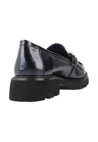 Mocassin en cuir verni noir avec une semelle épaisse et texturée, présentant une sangle décorative et un détail de boucle, vue d'angle depuis l'arrière.