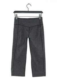 Černé sportovní kalhoty s texturovaným povrchem. Mají zvýrazněné švy a přiléhavý střih. Visí na černém plastovém ramínku.