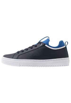 Niskie sneakersy w ciemnym granacie z czarnymi sznurówkami, niebieskim wyściełanym kołnierzem, białym obszyciem i grubą białą fakturowaną podeszwą.