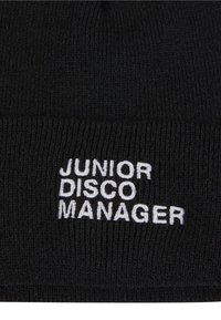 Melnā adīta beanie cepure ar baltu izšūtu tekstu "JUNIOR DISCO MANAGER" priekšpusē. Mīksta tekstūra un cieši pieguļ.