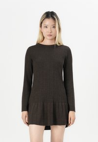 Abito a maglia marrone a coste con maniche lunghe, scollatura rotonda e orlo svasato. Texture morbida con linee verticali e silhouette aderente.