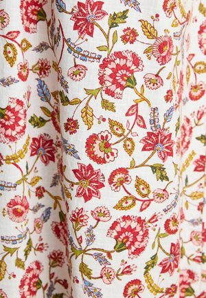 White fabric with a floral pattern in red, pink, green, and blue. Features intricate flowers and leaves, showcasing detailed embroidery.