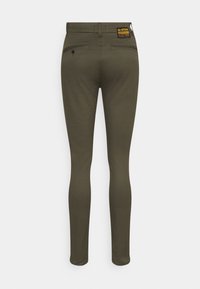 Smal passform, olivgröna byxor med en slät textur. Har två bakfickor, G-Star-logotyp på midjan och minimal design.