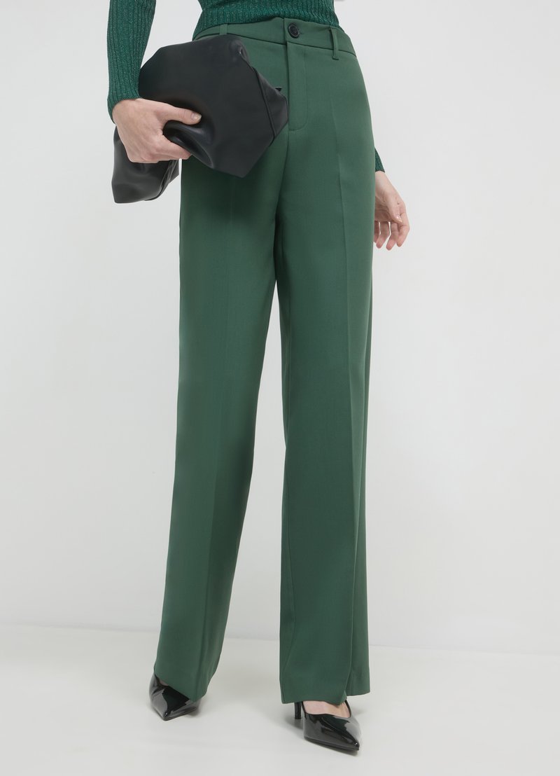 Pantalons taille haute verts en tissu lisse avec une coupe ajustée, dotés d'une fermeture par bouton à l'avant et d'un pli le long des jambes.