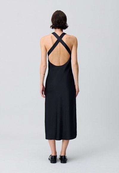 Robe midi en satin noir avec un dos plongeant et des bretelles croisées. Texture lisse et design minimaliste avec un détail de dos dénudé.