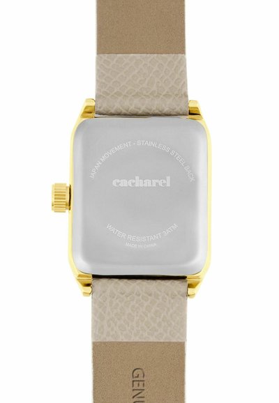 Vierkante horlogekast met goudkleurige achterkant en beige, textuurleren bandjes, gegraveerd met merknaam en technische details.