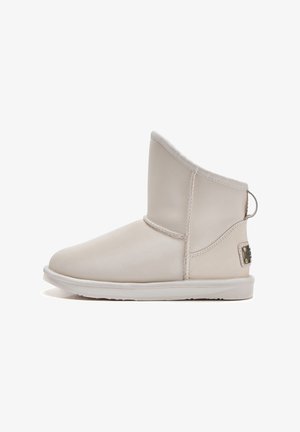 Béžové členkové topánky vyrobené z hladkej kože, so zaoblenou špičkou, nízkym podpätkom a malým detailom slučky na zadnej strane. Plochá gumová podrážka.