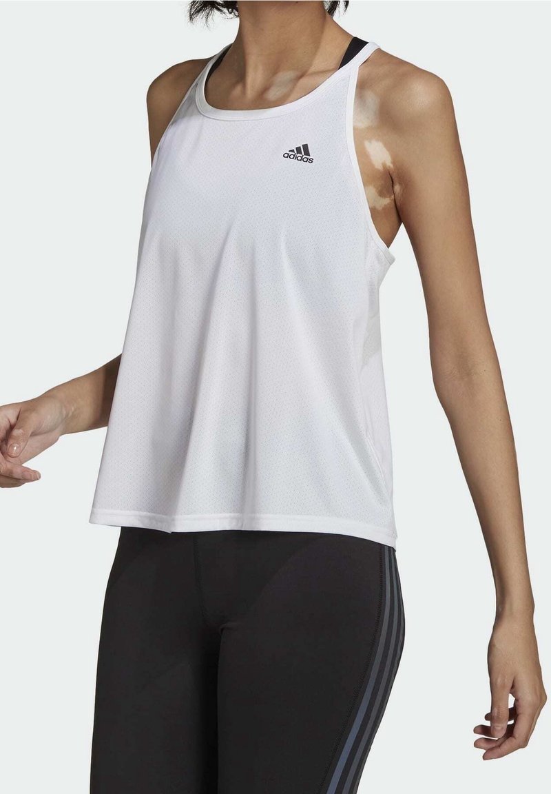 Vit, ärmlös atletisk linne i andningsbart tyg med rund halsringning och en Adidas-logotyp på vänster bröst.